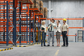 Description: Businesspeople and workers in warehouse